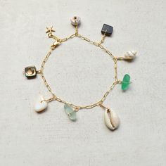 "This beautiful ocean inspired charm bracelet has an assortment of shells and cultured sea glass dangling from a textured cable chain and finished with a tiny gold filled starfish at the end. This bracelet is meant to dangle so I add 1/2\" to the length you order. Please allow for variations in size and shape of shells and sea glass." Beach Ocean-inspired Charm Bracelet, Gold Charm Bracelet With Starfish For Beach, Ocean-inspired Starfish Charm Bracelet For Beach, Pearl Bangles Gold, Sea Shell Bracelet, Bracelet Ocean, Beachy Bracelets, Pearl Bangle Bracelet, Sea Glass Bracelet