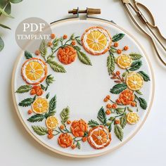 an embroidery project with oranges and leaves