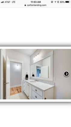 an image of a bathroom with white cabinets and marble counter tops on the right side