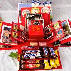 an assortment of candy and candies arranged in a star - shaped box on a bed