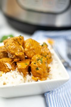 a white bowl filled with rice and meat next to an instant pot pressure cooker