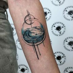 a person with a tattoo on their arm that has an image of the moon and stars in it