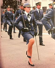 a group of women in uniform marching down the street