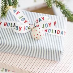 a christmas present wrapped in blue and white striped paper with a red polka dot ribbon