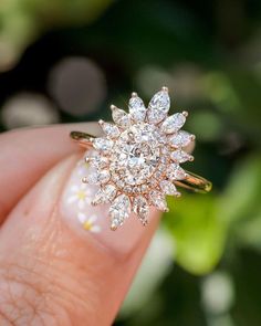 a close up of a person holding a ring with diamonds on it's finger