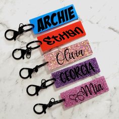 six pairs of personalized hair clips on a marble counter with scissors in the foreground