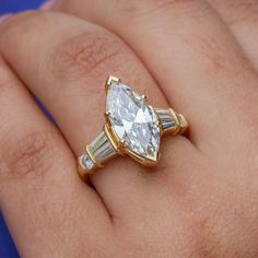 a close up of a person's hand with a diamond ring on top of it