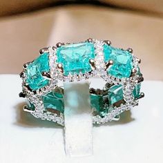 an emerald colored ring with diamonds on it