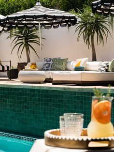 an outdoor lounge area next to a swimming pool