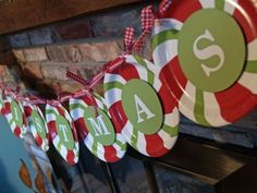 christmas paper plates are hanging on the mantle