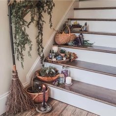 some plants are sitting on the stairs next to baskets with candles and other things in them