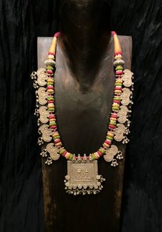 Get lost in the detail and unique beauty of antique silver Banjara beads strung onto a beautifully woven cord, handcrafted in India. All of our jewelry is one of a kind, handmade, and fair trade. A truly one of a kind piece, this necklace features the breathtaking intricacy of century old Banjara silverwork which is gracefully contrasted by the colorful and intricate woven cord they’re strung upon. The Banjara are one of the ancient nomadic tribes in India and have been known for centuries for t Fusion Multi-stone Pink Jewelry, Pink Multi-stone Necklace For Gift, Pink Multi-stone Necklace As Gift, Pink Multi-stone Necklaces For Gifts, Silver Multi-stone Temple Jewelry Necklace, Red Sterling Silver Necklace With Oxidized Finish, Sterling Silver Multi-stone Necklace For Wedding, Sterling Silver Multi-stone Wedding Necklaces, Pink Fusion Jewelry With Natural Stones