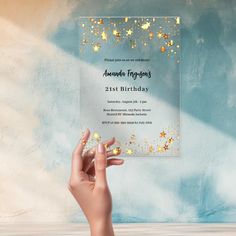 a hand holding up a birthday card with gold stars