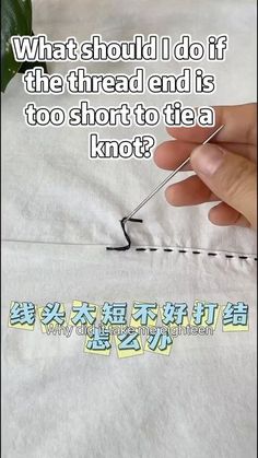 someone is stitching the thread on top of a piece of paper with words written below it