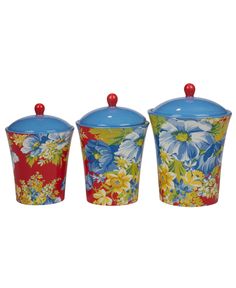 three vases with flowers painted on them and one has a red lid, the other blue