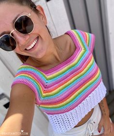 a woman wearing sunglasses taking a selfie in front of a door with her hand on her hip