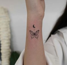 a woman's wrist with a small butterfly tattoo on the left side of her arm