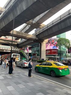 cars and people on the street under an overpass