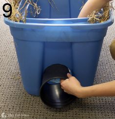 a person pushing a wheelbarrow with hay in it on the carpeted floor