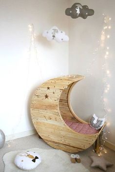 a child's room with a crescent shaped bed and lights on the wall above it