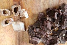 chopped mushrooms are sitting on a cutting board next to some diced up pieces of meat