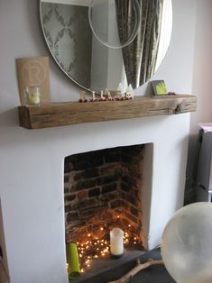 a living room filled with furniture and a fire place under a mirror on the wall