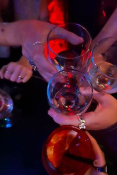 several people are holding wine glasses in their hands