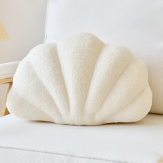 a white pillow sitting on top of a white couch