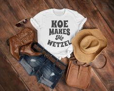 Koe Makes Me Wetzel Country Shirt  .: 100% Airlume combed and ringspun cotton (fiber content may vary for different colors) .: Light fabric (4.2 oz/yd² (142 g/m .: Retail fit .: Tear away label .: Runs true to size Pink Cowgirl Boots, Lyric Shirts, Taylor Swift Eras Tour, Taylor Swift Eras, Cowgirl Shirts, Festival Shirts, Cow Girl, Cowgirl Boots, Eras Tour