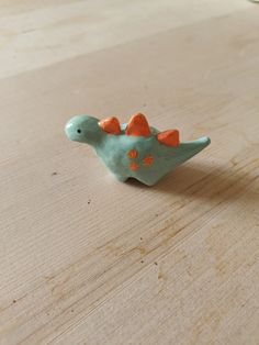 a small toy dinosaur sitting on top of a wooden table