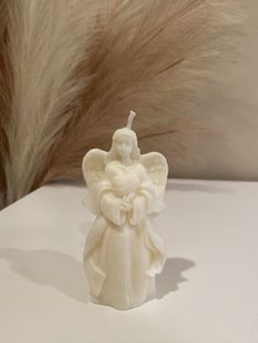 an angel figurine sitting on top of a table next to some pamodia