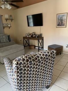 a living room filled with furniture and a flat screen tv mounted on the wall above it