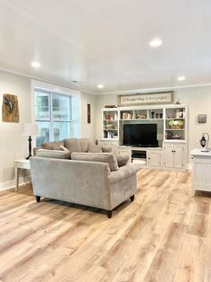 a living room filled with furniture and a flat screen tv on top of a wooden floor