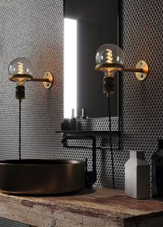 a bathroom with two lights on the wall and a round sink in front of it