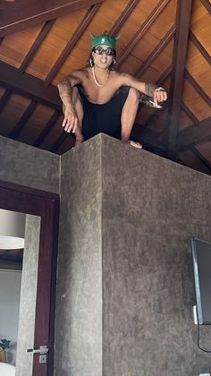 a woman standing on top of a box in a room with wood ceilinging and walls