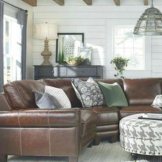 a living room filled with furniture and a large window covered in wood planks on the wall