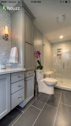 a bathroom with gray tile and white fixtures