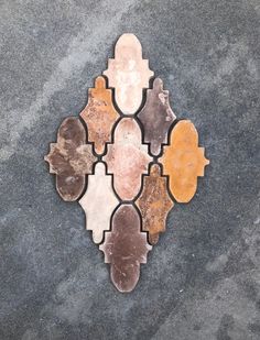 a tile design on the ground with different colors and shapes, including oranges, browns, yellows, and browns