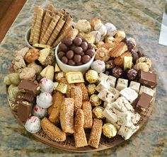 a platter filled with lots of different types of desserts and pastries on top of a table