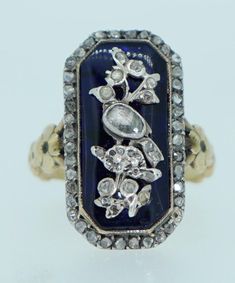 This is an exceptional original Georgian Era ring. It dates from the 1800s. It is crafted from solid 18K as well as sterling silver and natural rose cut diamonds. The underlying bristol blue glass is in wonderful condition, a couple of very very minor knicks on the edge. Pinned on to the top of the Bristol glass is a lovely bird perched on a floral branch. The bird is done in sterling silver and adorned with fine rose cut diamonds of various sizes. The diamonds are in good condition, a couple of very small diamonds missing on the branch area (not noticeable unless magnified). The boarder of this ring is covered in a frame of additional rose cut diamonds set in silver. The shoulders of this ring feature flowers. The shank and back of the ring are testing as solid 18K yellow gold (not hallma Victorian Blue Jewelry With Diamond Accents, Antique Blue Rings With Rose Cut Diamonds, Luxury Blue Jewelry With Rose Cut Diamonds, Luxury Victorian Jewelry With Rose Cut Diamonds, Victorian Blue Rings With Rose Cut Diamonds, Luxury Antique Sapphire Ring With Rose Cut Diamonds, Ornate Rose Cut Diamond Collectible Jewelry, Bird Rings, Floral Branch