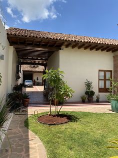 a house with a car parked in front of it and landscaping around the driveway area