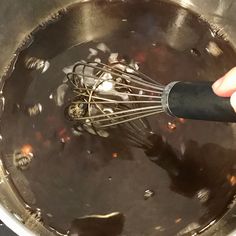 someone is whisking some food in a pot with something black on the side