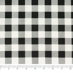 a black and white checkered fabric with a ruler in front of the plaid pattern