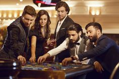 a group of people standing around a table playing a game of checkers in a casino