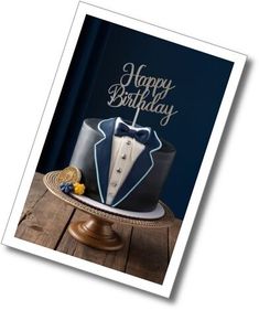 a happy birthday card with a tuxedo and bow tie cake on a wooden table