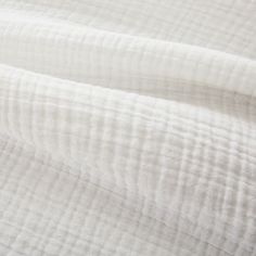 an image of white linen textured up close to the bed sheeting or coverlet