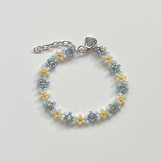 "Handmade Beaded Bracelet ✿ Made with glass seed beads and metal accents ✿ Dusk blue, light sea-foam, yellow, and ivory ✿ The bracelet has 1.5\" of extension chain" Blue And Yellow Beaded Bracelet, Blue And Yellow Bracelet, Light Blue Beaded Flower Jewelry, Light Blue Flower-shaped Beaded Jewelry, Blue Flower-shaped Jewelry With Beaded Chain, Light Blue Bracelets With Colorful Beads For Jewelry Making, Blue Beaded Bracelets With Extender, Mini Beads Bracelet, Yellow Beaded Bracelets