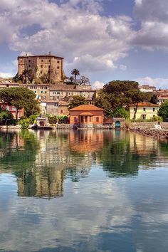 an old castle sits on top of a hill above the water