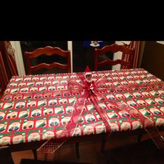 a table covered with a christmas present wrapped in red and green paper