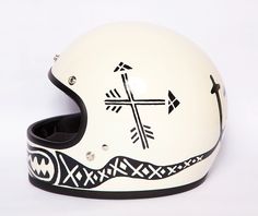 a white motorcycle helmet with an arrow and cross on the side, sitting against a white background